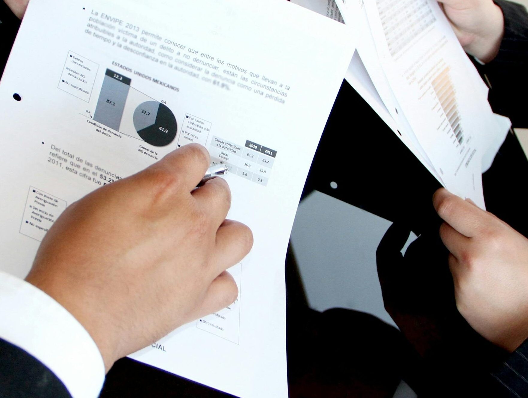 A business team reviewing charts and graphs on documents, emphasizing data analysis and teamwork.