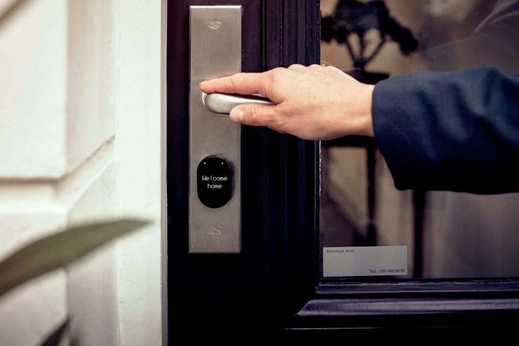 pexels-photo-6689288-6689288 A hand opening a smart home door with digital access panel, conveying security and technology.